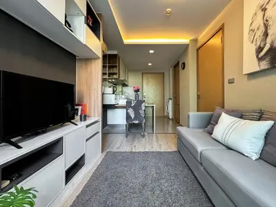 a living room with a couch and a flat screen tv at Stylish Premier 1BR - Ultra Fast Wifi - BTS Nana in Bangkok