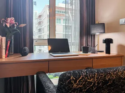 a desk with a laptop on it in a hotel room at Stylish Premier 1BR - Ultra Fast Wifi - BTS Nana in Bangkok