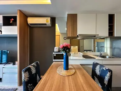 a kitchen with a table with a vase of flowers on it at Stylish Premier 1BR - Ultra Fast Wifi - BTS Nana in Bangkok