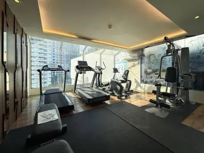 a gym with cardio equipment in a room with a large window at Stylish Premier 1BR - Ultra Fast Wifi - BTS Nana in Bangkok