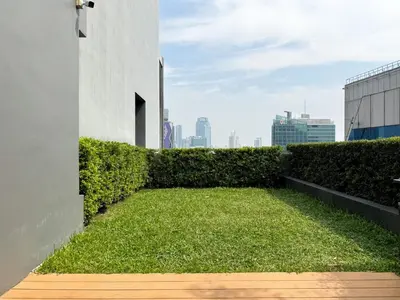 a yard of grass on the side of a building at Contemporary Stylish 1BR - Ultra Fast Wifi - Silom in Bangkok