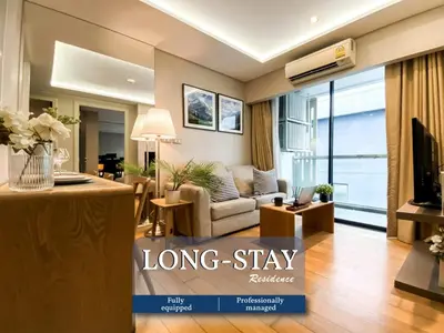 a living room with a long stay sign in a living room at Exquisite Modern 1BR - Ultra Fast Wifi - BTS Thong Lo in Bangkok