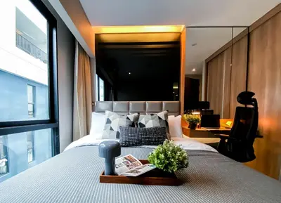 a bedroom with a large bed with a window at Exquisite Modern 1BR - Ultra Fast Wifi - BTS Thong Lo in Bangkok