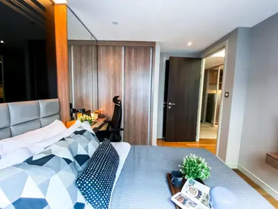 a bedroom with a bed and a table with plants on it at Exquisite Modern 1BR - Ultra Fast Wifi - BTS Thong Lo in Bangkok