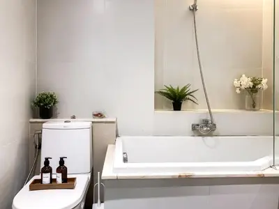 a bathroom with a bath tub and a toilet at Exquisite Modern 1BR - Ultra Fast Wifi - BTS Thong Lo in Bangkok