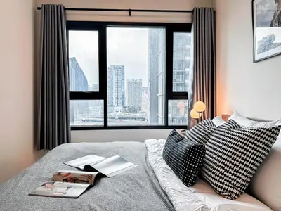 a bedroom with a bed with a view of a city at Luxury City-Scape 2BR - Ultra Fast Wifi - Asoke in Bangkok