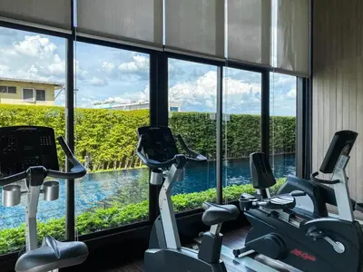 a gym with two exercise bikes in front of a window at Cityscape Modern Apt - Ultra Fast Wifi - Phra Khanong in Bangkok
