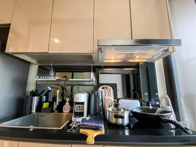 a kitchen counter with a sink and a microwave at Cityscape Modern Apt - Ultra Fast Wifi - Phra Khanong in Bangkok