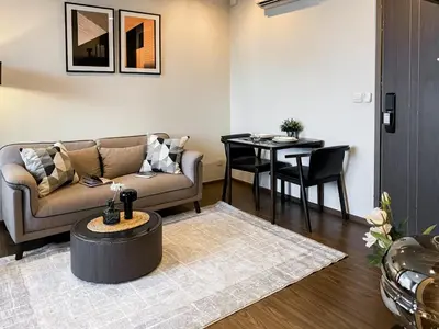 a living room with a couch and a table at Cityscape Modern Apt - Ultra Fast Wifi - Phra Khanong in Bangkok