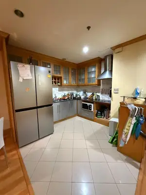 a kitchen with a refrigerator and a tile floor at Royal Place Apartments in Bangkok