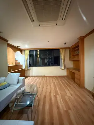 a living room with a white couch and a wooden floor at Royal Place Apartments in Bangkok
