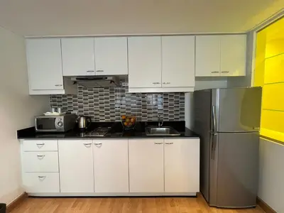 a kitchen with white cabinets and a stainless steel refrigerator at ห้องใหญ่ วิวดี กลางเมือง ใกล้บีทีเอส in Bangkok