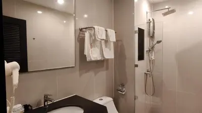 a bathroom with a sink and a shower with a mirror at Avana Bangkok Hotel & Convention Centre in Bangna