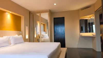 a bedroom with a white bed and a black door at Avana Bangkok Hotel & Convention Centre in Bangna