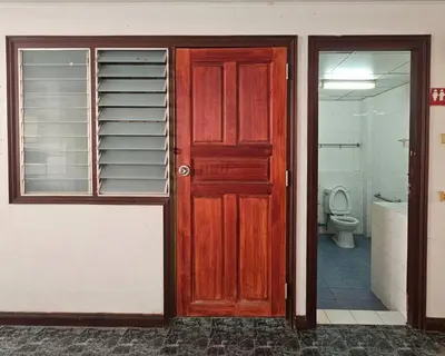 a red door in a bathroom with a toilet at City Living in Bangkok