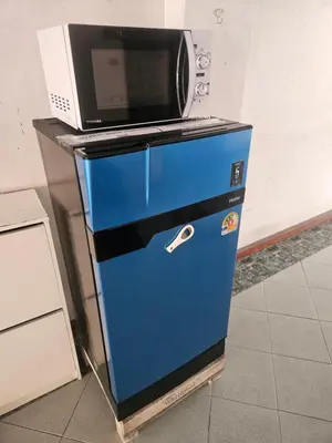 a microwave sitting on top of a blue refrigerator at City Living in Bangkok