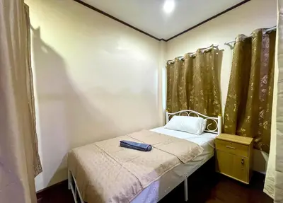 a small bedroom with a small bed with curtains at TheStarHome Sukhumvit71 in Bangkok