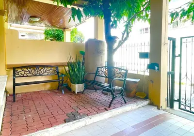 a bench sitting on a brick patio with a tree at TheStarHome Sukhumvit71 in Bangkok
