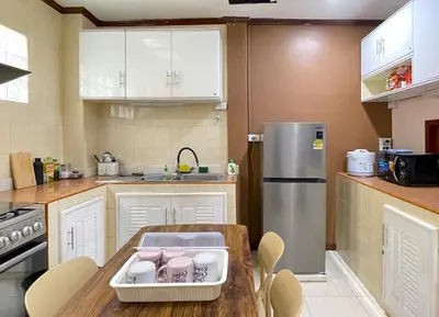 a kitchen with a table and a refrigerator at TheStarHome Sukhumvit71 in Bangkok