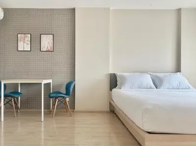 a bedroom with a bed and a table and two chairs at Gfeel X Elio Sukhumvit64 in Bangkok