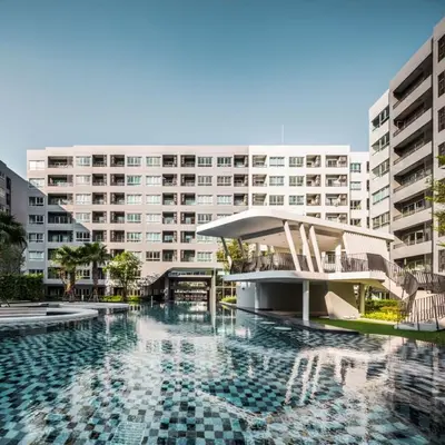 a swimming pool in front of a large building at Gfeel X Elio Sukhumvit64 in Bangkok