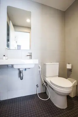 a bathroom with a white toilet and a sink at Gfeel X Elio Sukhumvit64 in Bangkok