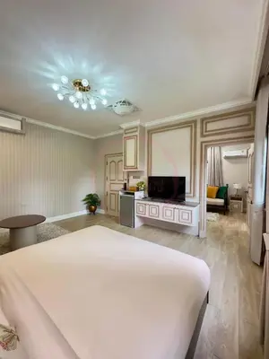 a bedroom with a bed and a living room at บ้านคุณนาย BaanKhunNaiPhaholyothin24 in Bangkok
