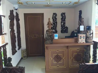 a room with a altar with statues on the wall at Kim Hotel At Morleng in Bangkok
