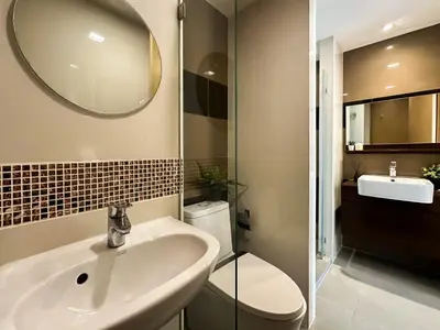 a bathroom with a sink and a toilet and a mirror at Contemporary Premier 1BR - Ultra Fast Wifi - BTS Nana in Bangkok