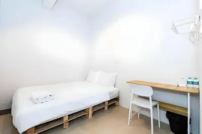 a bed in a room with a desk and a chair at XX Mitr INN Sukhumvit 2 - BTS Nana in Bangkok