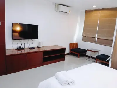 a hotel room with a bed and a tv on the wall at XX Yon INN Sukhumvit 4- BTS Nana in Bangkok