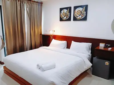 a hotel room with two beds with white sheets at XX Yon INN Sukhumvit 4- BTS Nana in Bangkok