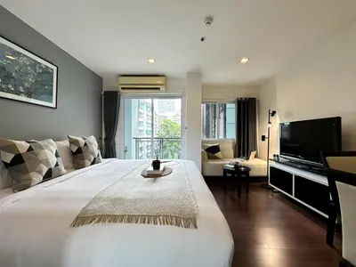 a bedroom with a large bed and a television at Modern Cityscape1BR - Ultra Fast WiFi - BTS On nut in Bangkok