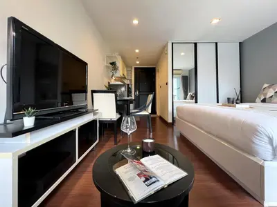 a living room with a large television and a couch at Modern Cityscape1BR - Ultra Fast WiFi - BTS On nut in Bangkok
