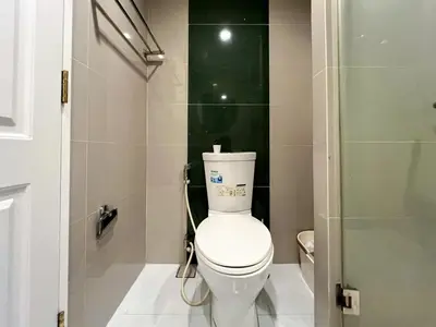 a bathroom with a white toilet and a shower at Modern Cityscape1BR - Ultra Fast WiFi - BTS On nut in Bangkok