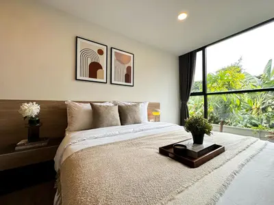 a bedroom with a large bed and a large window at Serene Tropical 1BR - Ultra Fast Wifi - Sathorn in Bangkok