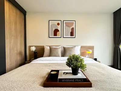 a bedroom with a large bed with a table on it at Serene Tropical 1BR - Ultra Fast Wifi - Sathorn in Bangkok