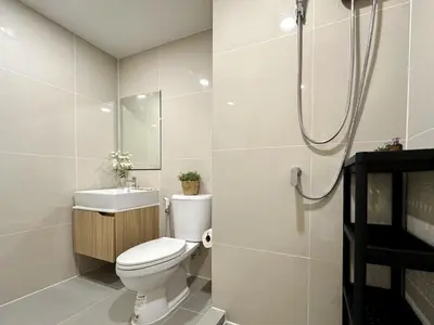 a bathroom with a toilet and a sink and a shower at Serene Tropical 1BR - Ultra Fast Wifi - Sathorn in Bangkok