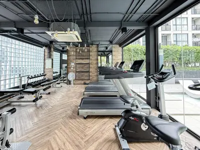 a gym with a row of treadms and cardio machines at Serene Tropical 1BR - Ultra Fast Wifi - Sathorn in Bangkok