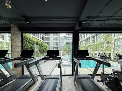 a gym with three rows of treadmill desks with laptops on them at Serene Tropical 1BR - Ultra Fast Wifi - Sathorn in Bangkok