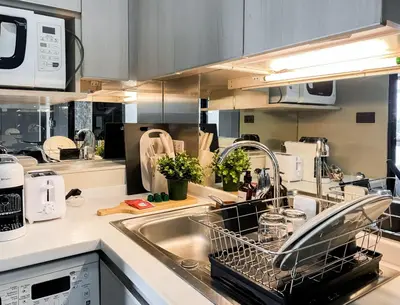 a kitchen with a dish drying rack in the sink at Tropical Urban 43 Sqm - Ultra Fast Wifi - Thong Lo in Bangkok