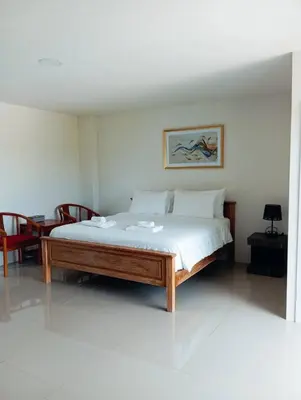 a large bed in a room with a table at VS Place in Nonthaburi