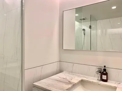 a white bathroom with a sink and a mirror at Sathorn Prime Residence 2BR #Bangkok in Bangkok