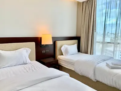 a hotel room with two beds and a window at Sathorn Prime Residence 2BR #Bangkok in Bangkok