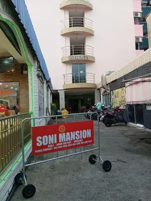 a sign on a cart in front of a building at Hotel Soni Mansion Pratunam in Bangkok