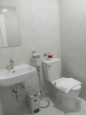 a bathroom with a white toilet and a sink at VS Place in Nonthaburi