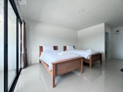 a bedroom with two beds and a table at VS Place in Nonthaburi