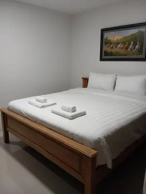 a bed with two white towels on top of it at VS Place in Nonthaburi