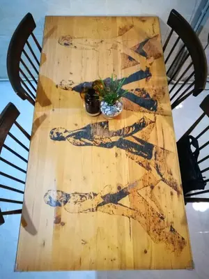 a wooden table with a painting of a man on it at Gallery house 177-3min walk BTS near icon siam in Bangkok