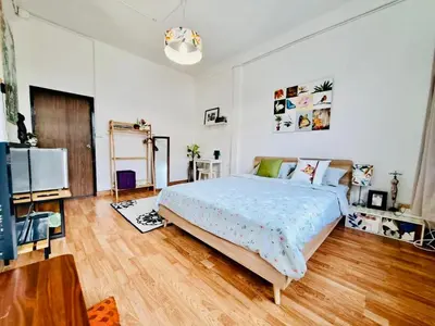 a bedroom with a large bed and a wooden floor at Gallery house 177-3min walk BTS near icon siam in Bangkok